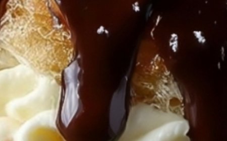 Cream-filled pastries with chocolate glaze and powdered sugar