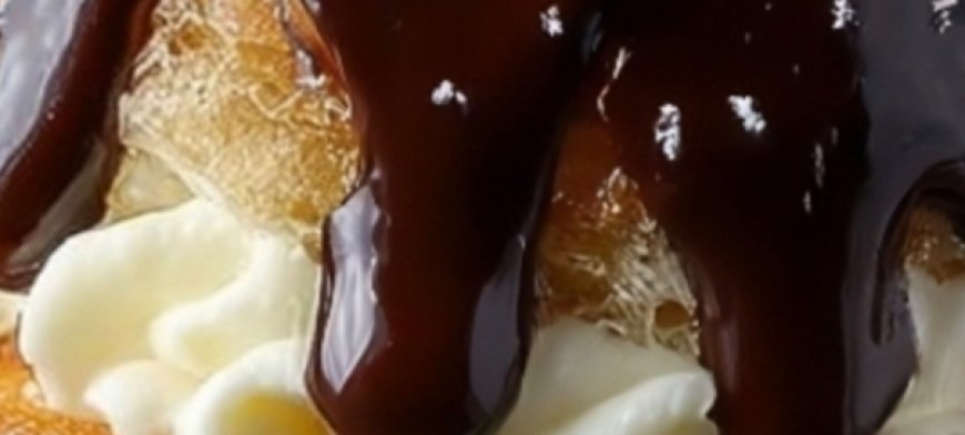 Cream-filled pastries with chocolate glaze and powdered sugar